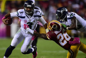 Russell Wilson stiff-arms Bashaud Breeland in the first quarter Monday night. Wilson ran for 122 yards and a TD. (Getty Images)